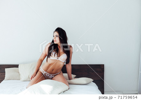 Beautiful brunette woman in lingerie in the bedroom on the bed 71759654