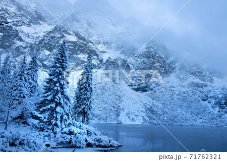 Winter mountain landscape. Icy lake in winter snowy forest. Beautiful frozen nature. 71762321