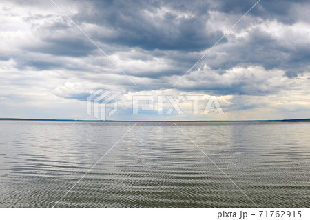 Shore of a large lake or sea on a cloudy day. Shore of a large lake or sea on a cloudy day. 71762915