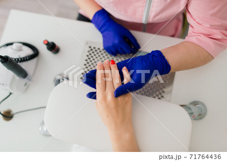 Female manicure master in a beauty salon work with hands of the client Female manicure master in a beauty salon work with hands of the client 71764436