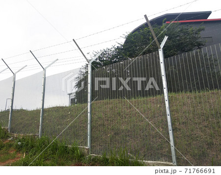 MELAKA, MALAYSIA -JUNE 5, 2020: Anti-climb fencing made from galvanized iron install at the perimeter or property boundary to prevent from the intruder. Its close nets can prevent intruders from climb MELAKA, MALAYSIA -JUNE 5, 2020: Anti-climb fencing made from galvanized iron install at the perimeter or property boundary to prevent from the intruder. Its close nets can prevent intruders from climb 71766691