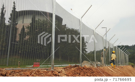 MELAKA, MALAYSIA -JUNE 5, 2020: Anti-climb fencing made from galvanized iron install at the perimeter or property boundary to prevent from the intruder. Its close nets can prevent intruders from climb MELAKA, MALAYSIA -JUNE 5, 2020: Anti-climb fencing made from galvanized iron install at the perimeter or property boundary to prevent from the intruder. Its close nets can prevent intruders from climb 71766695