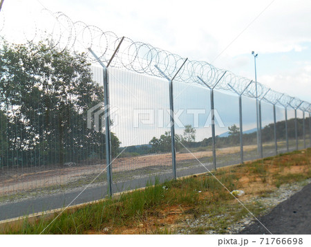 MELAKA, MALAYSIA -JUNE 5, 2020: Anti-climb fencing made from galvanized iron install at the perimeter or property boundary to prevent from the intruder. Its close nets can prevent intruders from climb MELAKA, MALAYSIA -JUNE 5, 2020: Anti-climb fencing made from galvanized iron install at the perimeter or property boundary to prevent from the intruder. Its close nets can prevent intruders from climb 71766698