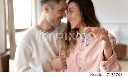 Couple hugging holding keys to the new house, closeup 71767034
