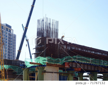MALACCA, MALAYSIA -MARCH 2, 2020: Construction workers working at height install reinforcement bars at the construction site. They are supplied with harnesses and other safety equipment. MALACCA, MALAYSIA -MARCH 2, 2020: Construction workers working at height install reinforcement bars at the construction site. They are supplied with harnesses and other safety equipment. 71767132