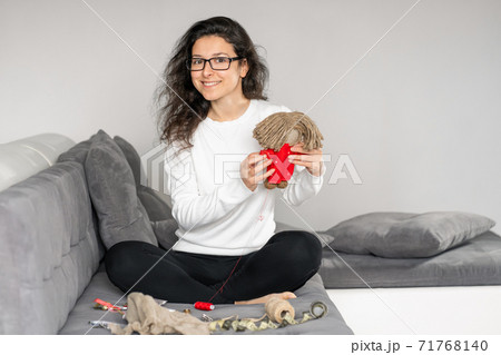 Handicraft is a fascinating hobby. The person sews dolls at their leisure Handicraft is a fascinating hobby. The person sews dolls at their leisure 71768140