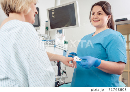 Nurse preparing blood pressure sensor for surgery on patient Nurse preparing blood pressure sensor for surgery on patient 71768603