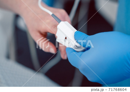Nurse in hospital putting blood pressure sensor on patient's finger Nurse in hospital putting blood pressure sensor on patient's finger 71768604