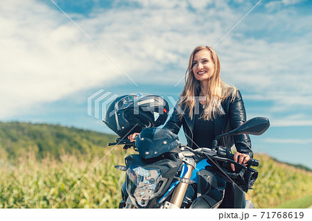 Beautiful woman on a motorcycle looking at the road ahead Beautiful woman on a motorcycle looking at the road ahead 71768619