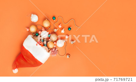 christmas decorations fall out of santa hat on orange background christmas decorations fall out of santa hat on orange background 71769721