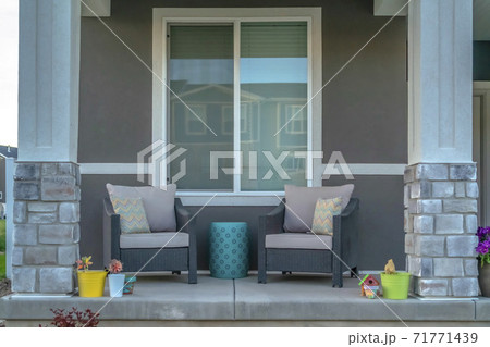 Furniture against the window at the front porch with pillars of a lovely home Furniture against the window at the front porch with pillars of a lovely home 71771439