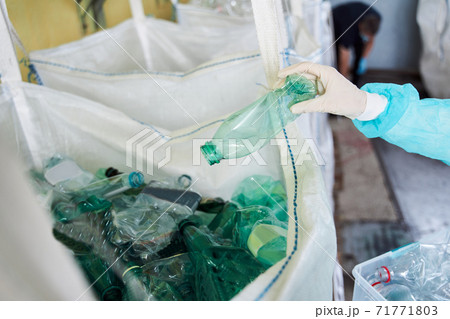 Woman sorting plastic bottles by colors 71771803