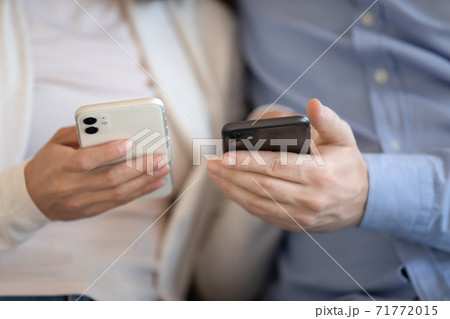 Close up of modern smartphones in male and female hands Close up of modern smartphones in male and female hands 71772015