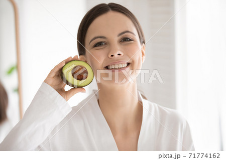 Active young lady posing with half of avocado in hand Active young lady posing with half of avocado in hand 71774162