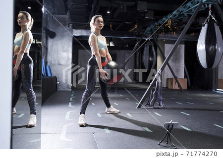 Woman in gym clothing doing core exercises Woman in gym clothing doing core exercises 71774270