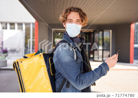 Man standing at the street with backpack with food 71774780