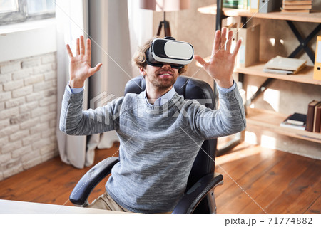 Man in virtual reality headset or 3d glasses at his workplace Man in virtual reality headset or 3d glasses at his workplace 71774882