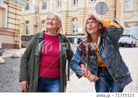 Woman admiring the sights with her elderly mother Woman admiring the sights with her elderly mother 71775525