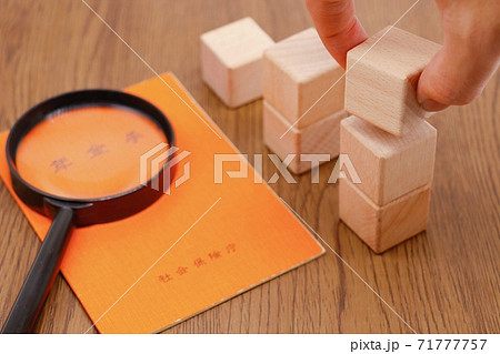 年金手帳と拡大鏡 71777757