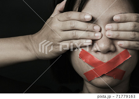 Asian woman blindfold wrapping mouth with red adhesive tape Asian woman blindfold wrapping mouth with red adhesive tape 71779163
