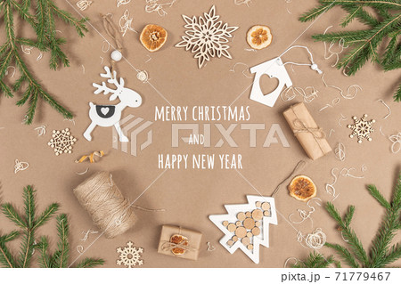 XMAS or New Year postcard. Frame, border made from boxes, twine, wood decoration, dried oranges and spruce branches on craft beige background. Concept Zero waste Merry Christmas Copy space 71779467