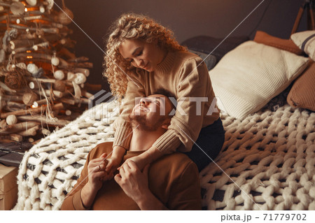 Elegant couple sitting at home near christmas tree 71779702