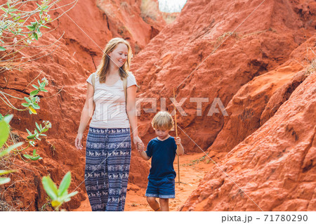 Mother and son travelers in red canyon near Mui Ne, southern Vietnam. Traveling with children concept Mother and son travelers in red canyon near Mui Ne, southern Vietnam. Traveling with children concept 71780290
