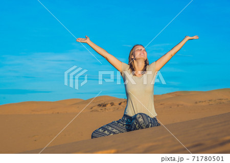 young woman in rad sandy desert at sunset 71780501