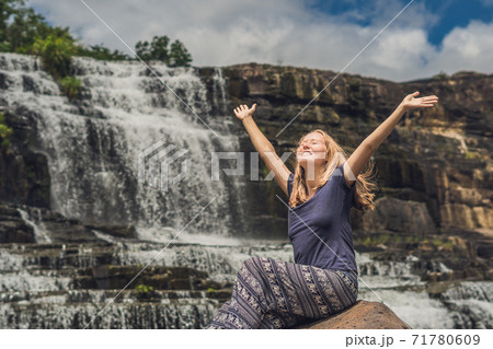 Young woman hiker, tourist on the background of Amazing Pongour Waterfall is famous and most beautiful of fall in Vietnam. Not far from Dalat city estimate 45 Km. Dalat, Vietnam 71780609