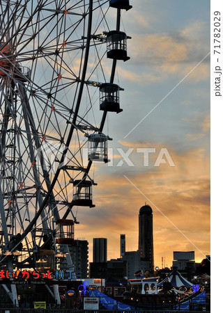 山口県下関市のあるかぽーとにある大型観覧車やビルが夕焼けの空を背景に美しく立つ風景2の写真素材