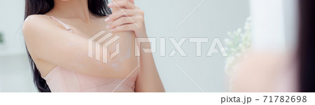 Beautiful young asian woman looking mirror applying cream on arms and message. Beautiful young asian woman looking mirror applying cream on arms and message. 71782698