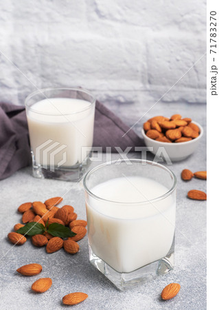 Almond milk in glass glasses on a gray background. Copy space. 71783270