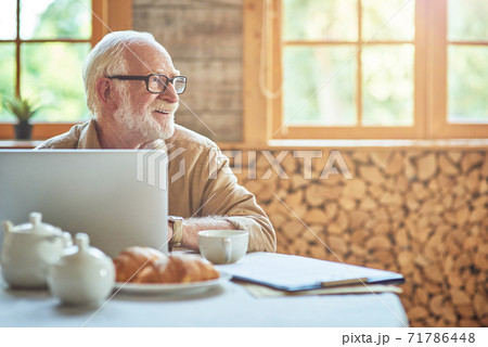 Smiling male pensioner looking away in the room Smiling male pensioner looking away in the room 71786448