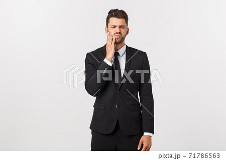 Strong toothache - businessman in pain. Portrait young adult businessman isolated against white background. Short-haired male. Strong toothache - businessman in pain. Portrait young adult businessman isolated against white background. Short-haired male. 71786563