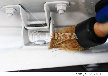 ドアヒンジの隙間に溜まった汚れをディテイリングブラシで除去の写真素材