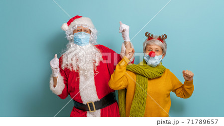Santa Claus and reindeer in face masks during Covid-2019 71789657