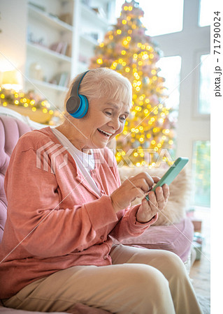 Woman holding a smartphone and watching something online Woman holding a smartphone and watching something online 71790024