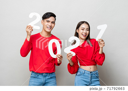 Happy Asian couple smiling and showing number 2021 for new year concept Happy Asian couple smiling and showing number 2021 for new year concept 71792663