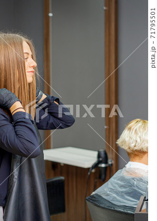 Hairdresser puts on black apron Hairdresser puts on black apron 71795501