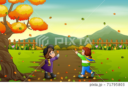 Happy girls catching falling leaf in autumn landscape 71795803