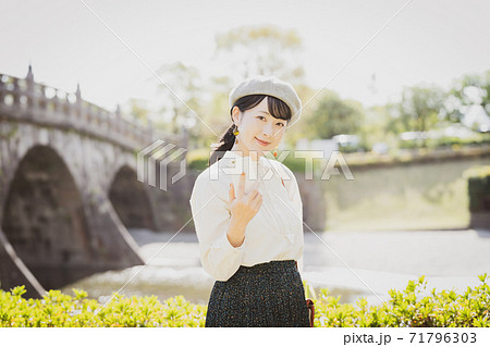 観光地でスマートフォンを持つ女性 71796303