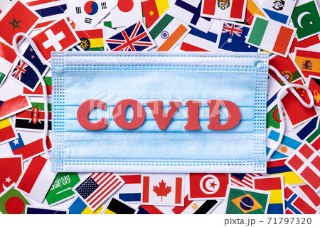 Medical masks with word covid written red colors on the background from national flags. 71797320