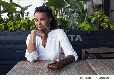 young pretty african girl posing cheerful in cafe outdoor, lifestyle people concept young pretty african girl posing cheerful in cafe outdoor, lifestyle people concept 71800567