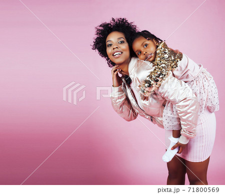young pretty african-american mother with little cute daughter hugging, happy smiling on pink background, lifestyle modern people concept 71800569