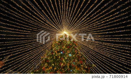 Beautiful illumination in the form of a tent over the New Year tree in the city. 71800914