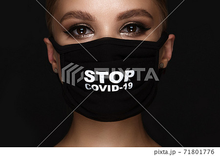 Portrait of a beautiful woman in a black mask stop covid and classic makeup. Mask mode during the covid pandemic 71801776