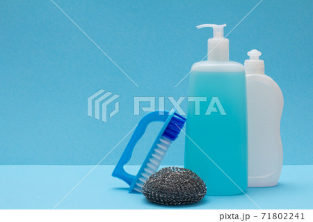 Bottles of dishwashing liquid, brush and sponge on blue background. 71802241