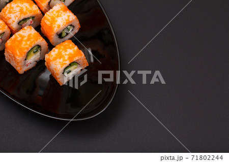Uramaki California. Sushi rolls on a plate with black background. 71802244