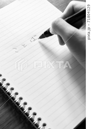 ノートとペンでキャッチコピーのアイデアを出すコピーライター モノクロの写真素材