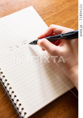 ノートとペンでキャッチコピーのアイデアを出すコピーライターの写真素材